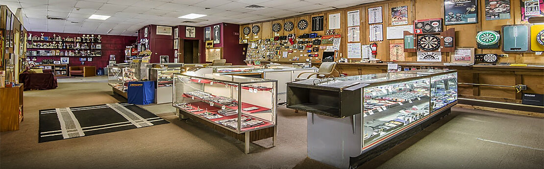 The Horizon Darts showroom, with dartboards on the wall and darts in glass display cases